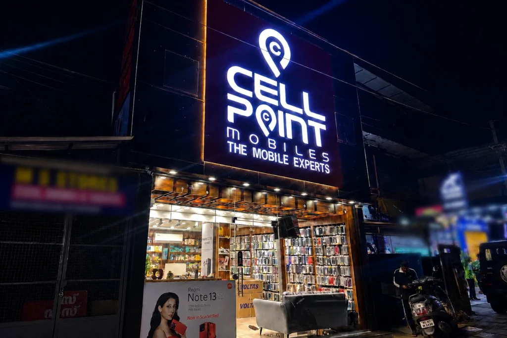 Sell Point Mobiles store showcasing smartphones, mobile accessories, phone cases, and repair services at night.